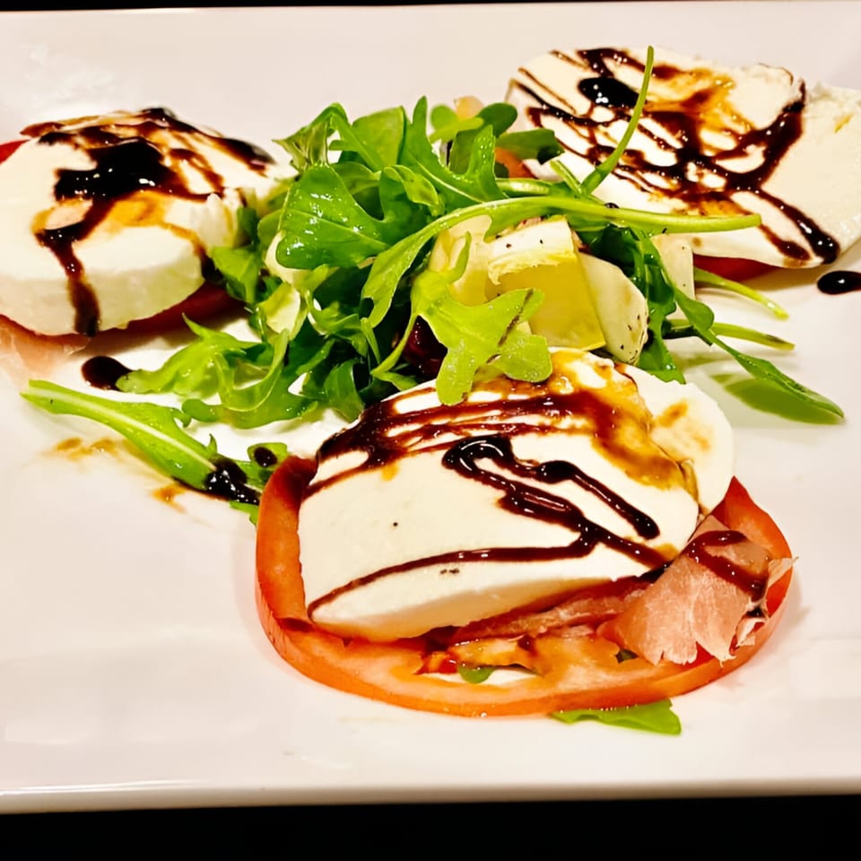 Pavesi Restaurant's Caprese salad with fresh mozzarella, tomatoes, prosciutto, arugula, and balsamic glaze.