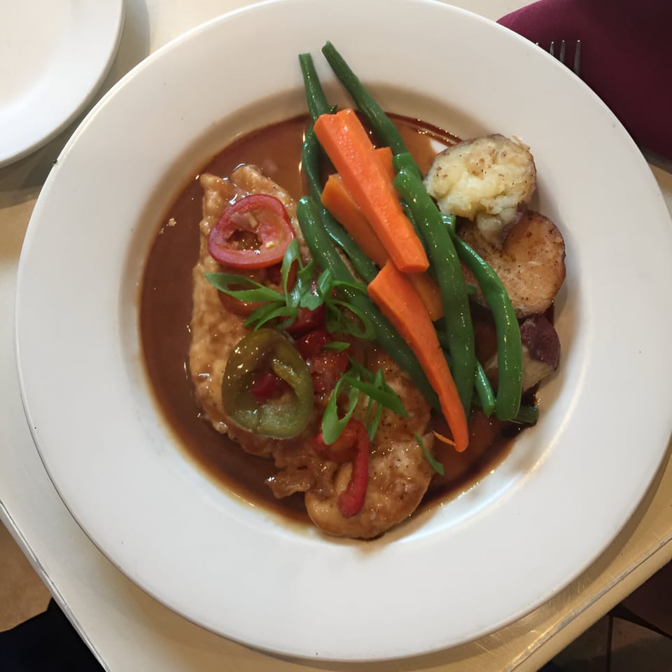 Pavesi Restaurant's chicken dish with green beans, carrots, potatoes, and peppers in a savory sauce.